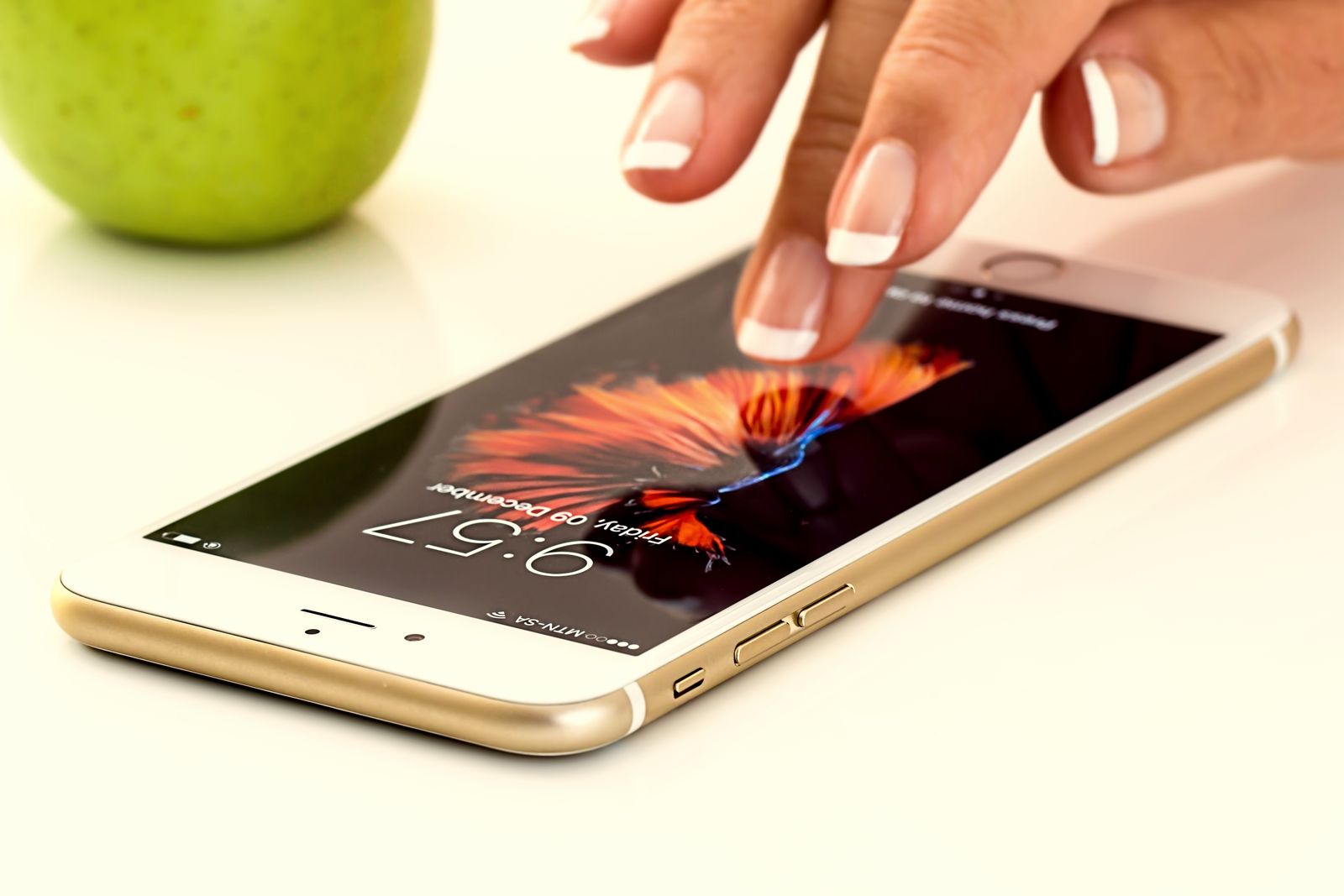 A finger tapping the screen of a smartphone lying on a table