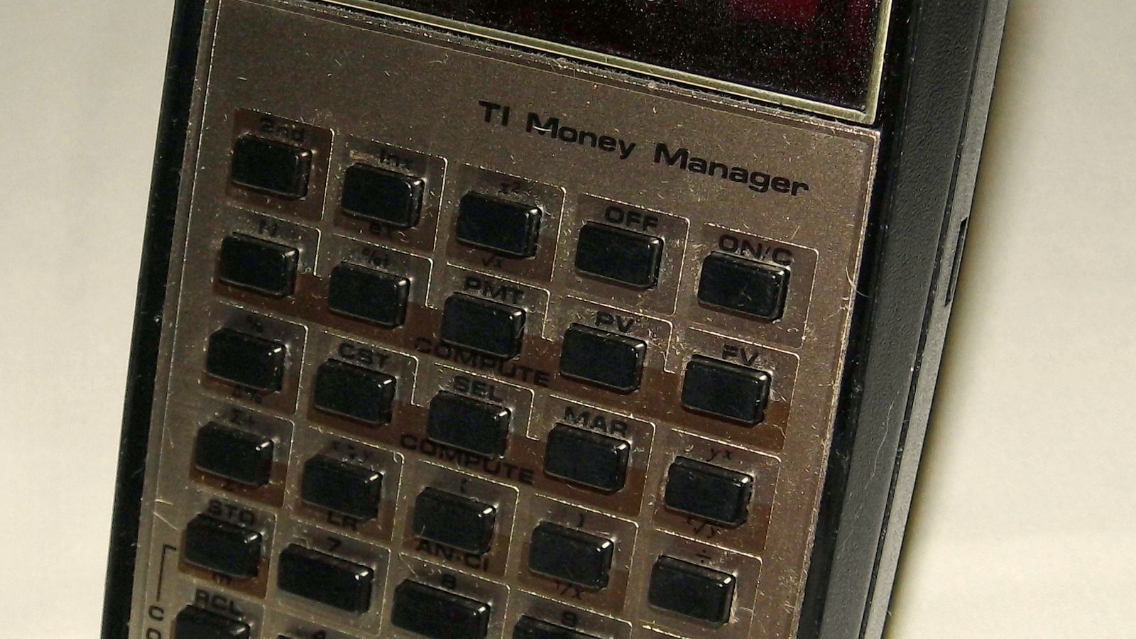 A vintage financial calculator with a red LED display