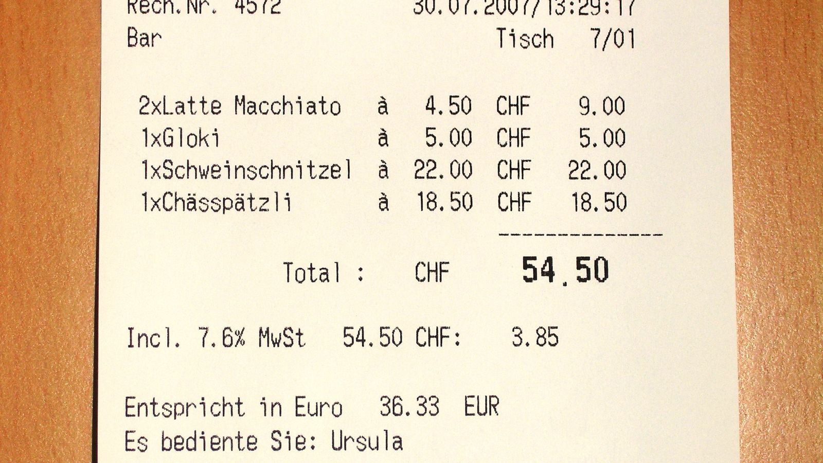A printed restaurant bill listing items and a total