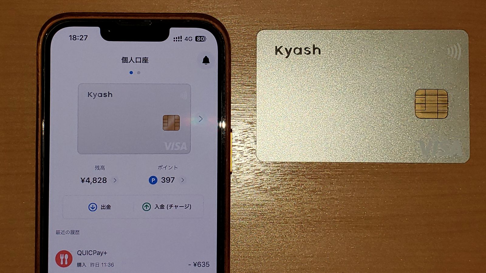 A prepaid payment card next to a phone showing the card's app and balance