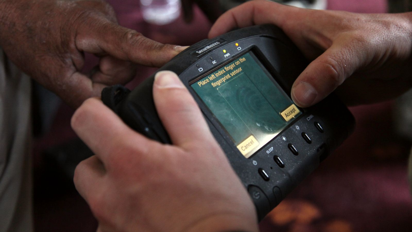 Hands holding a handheld biometric identity scanner