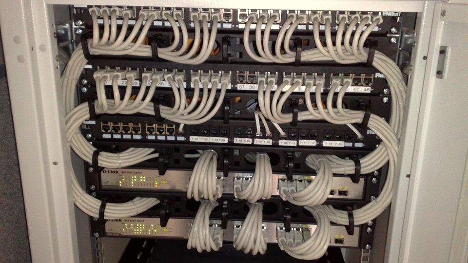 A rack of network switches with neatly patched cables