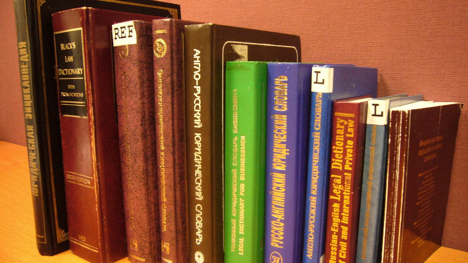 A row of legal dictionaries and law books on a desk
