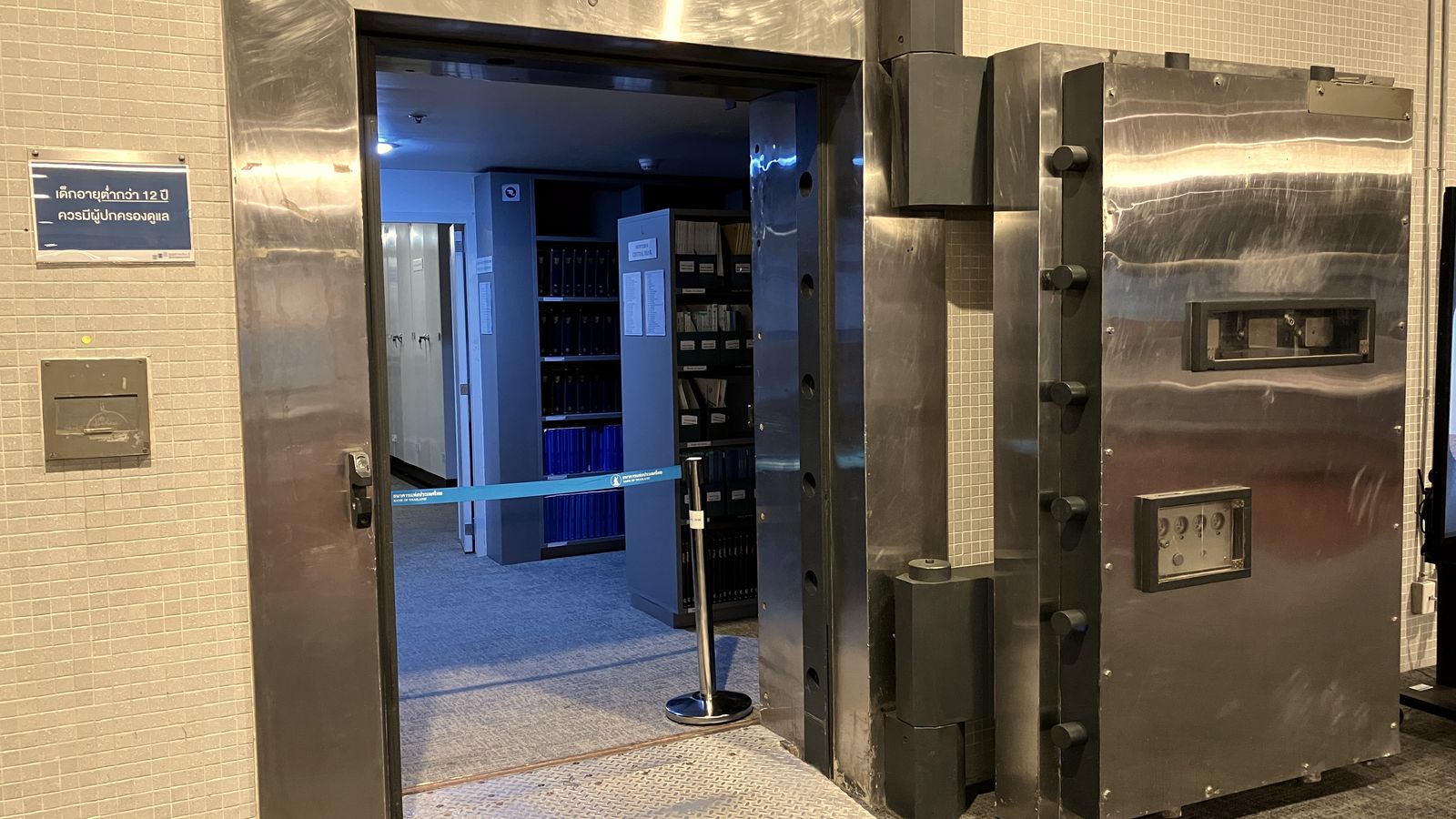 The heavy round-edged door of a bank vault standing open