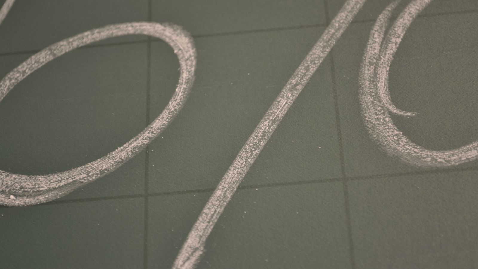 A large percent sign drawn in chalk on a grey board