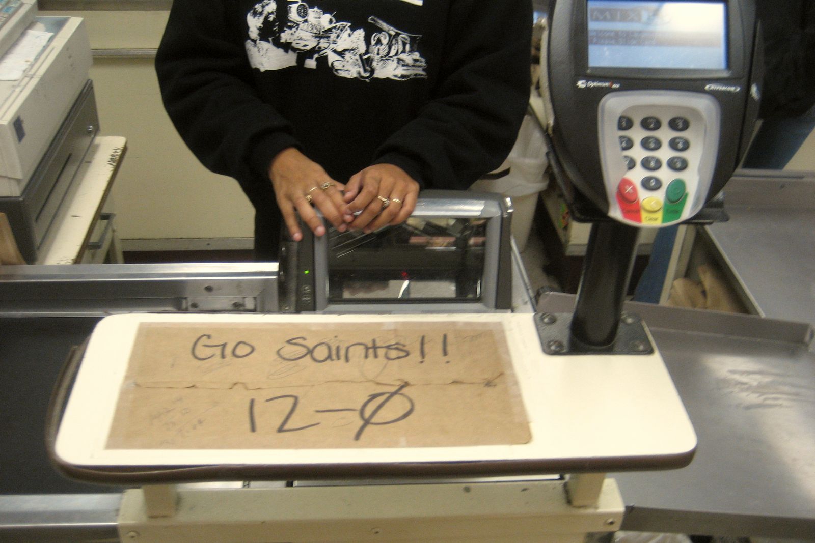 A shopper's hands at a supermarket card reader
