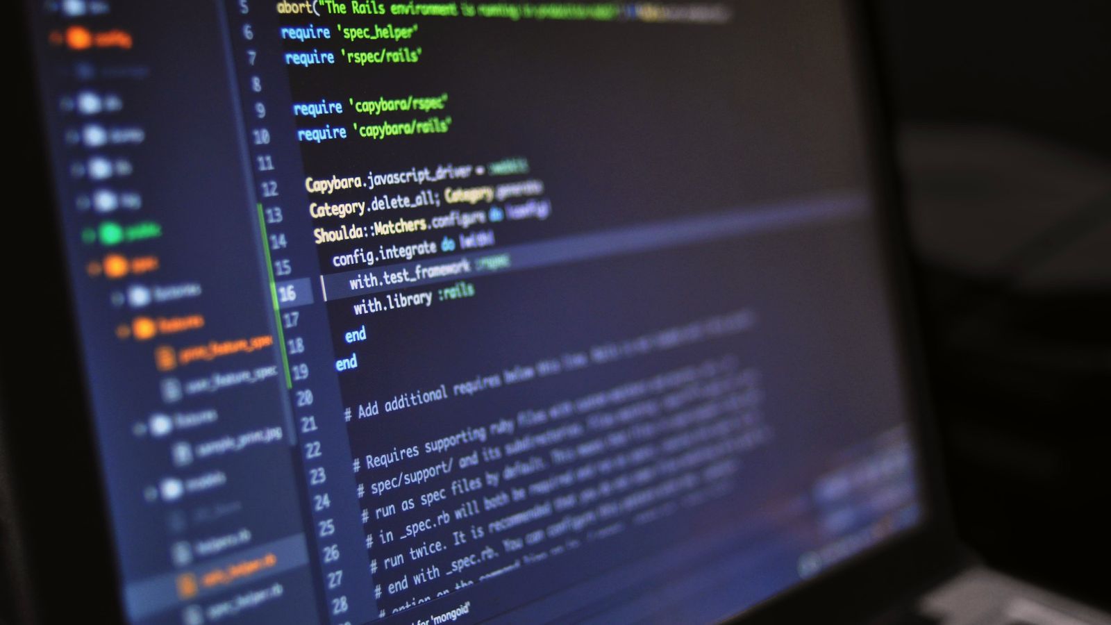 Lines of program code on a laptop screen in a dark room