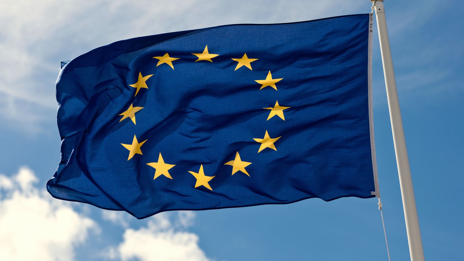 The European Union flag flying against a blue sky