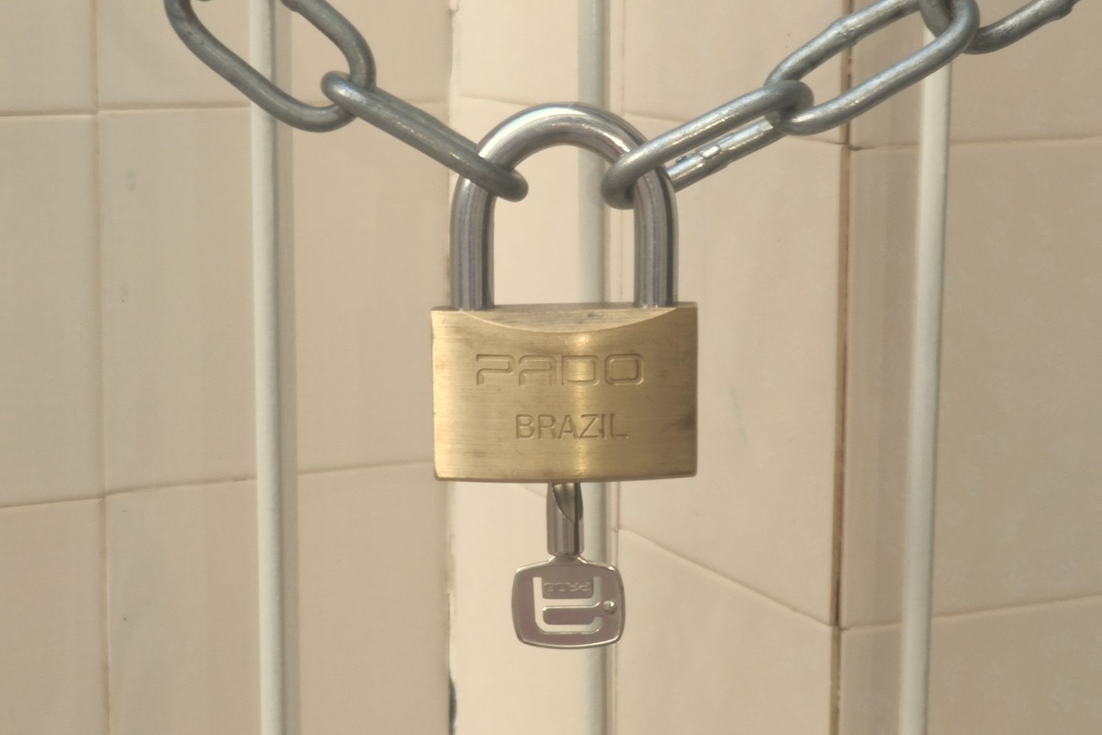 A padlock and chain holding two door handles together