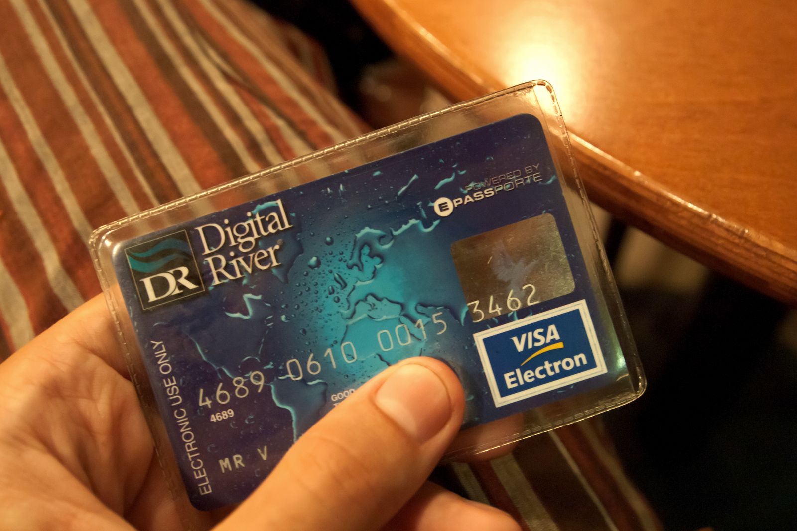 A hand holding a Visa Electron debit card