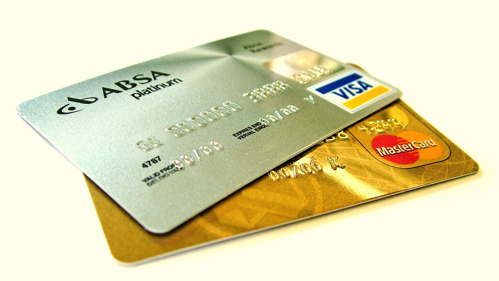 Two payment cards, one silver and one gold, lying on top of each other