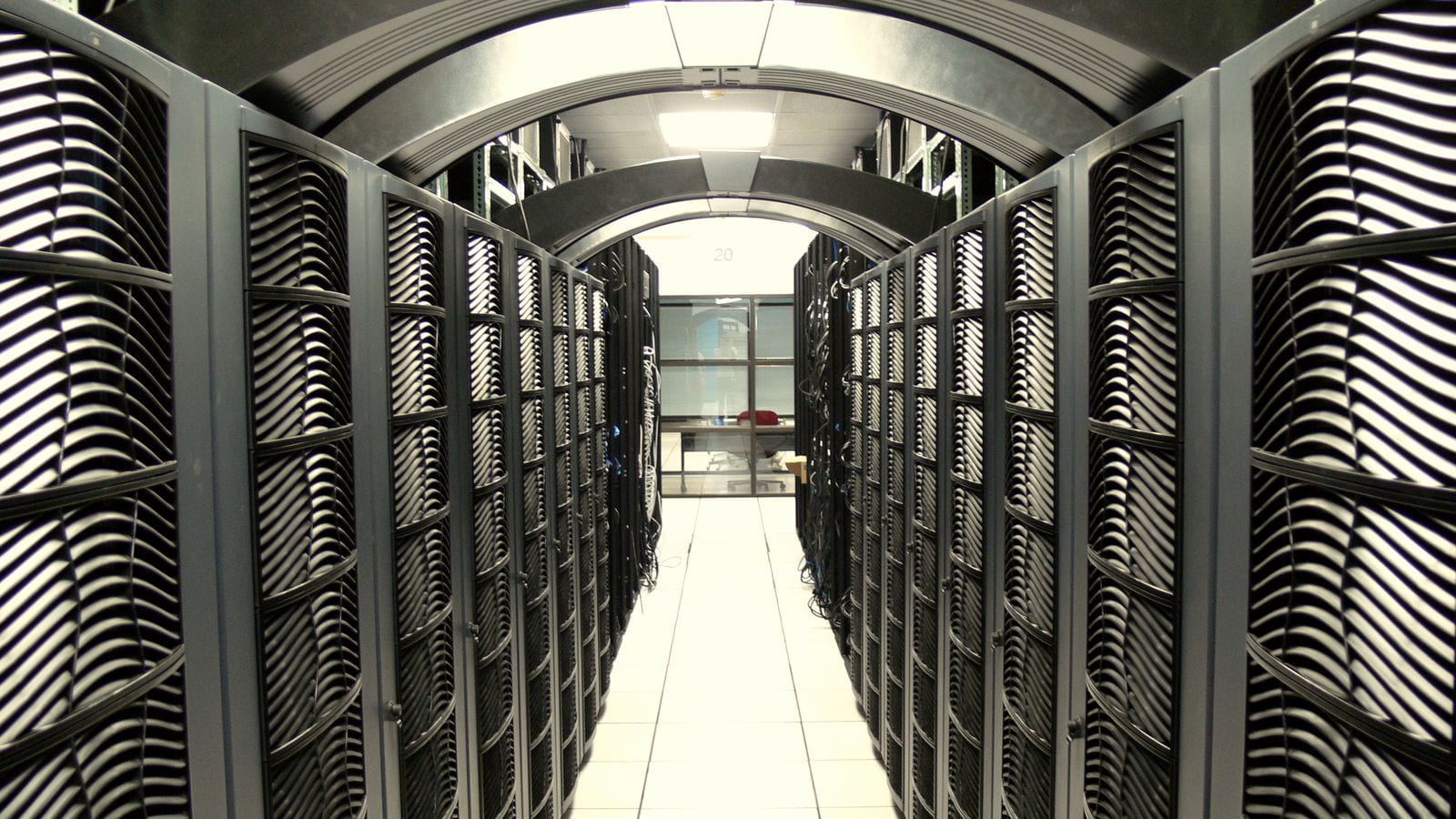 A long corridor between rows of server racks in a data centre