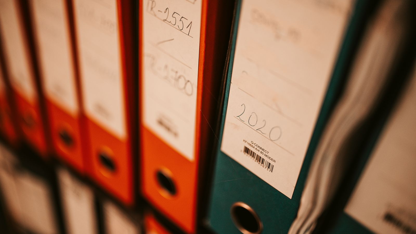 Rows of labelled ring binders on an office shelf